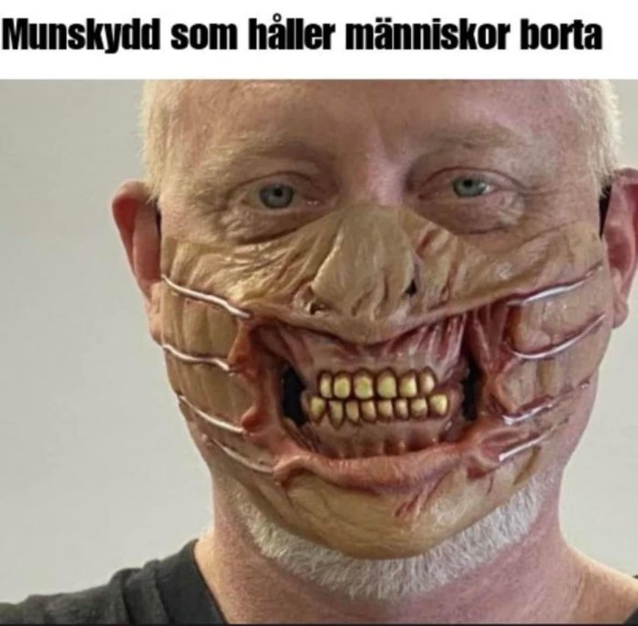 Man bär munskydd med skrämmande zombie-design för att illustrera munskydd som ska hålla människor borta.