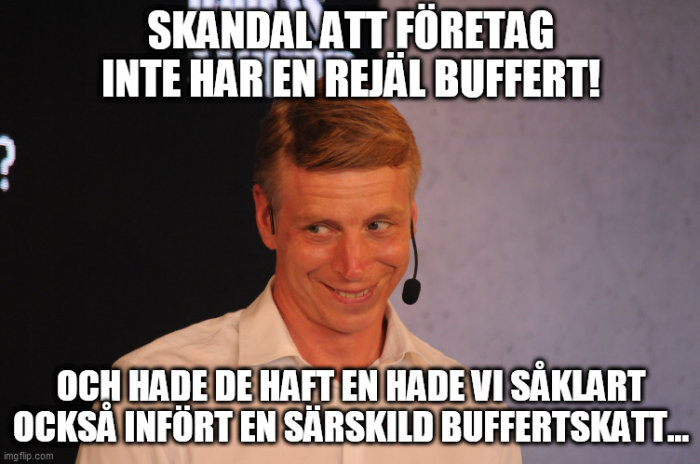 Man i mikrofonhörlurar ler ironiskt med meme-text om företags buffertar och skatter.