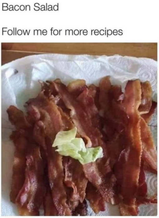 Stekt bacon på en tallrik med ett litet blad grönsallad ovanpå.