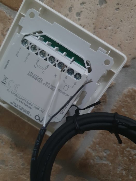 En ny digital termostat med öppet kopplingsutrymme och icke-anslutna kablar.