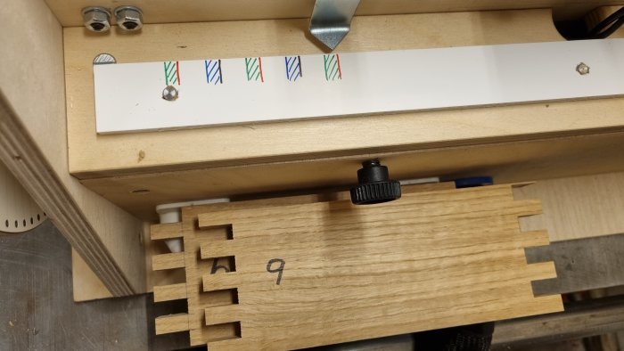 Träfog med fina 1mm delningar skapade av en boxjointjig, visas nära skruvjustering.