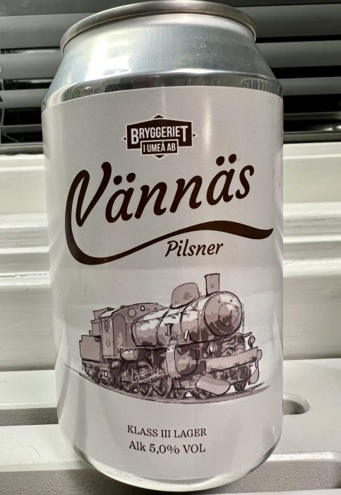 Ölburk med etikett för "Vännäs Pilsner" från "Bryggeriet Umeå AB" med en bild av ett ånglok, Alk 5,00% VOL.