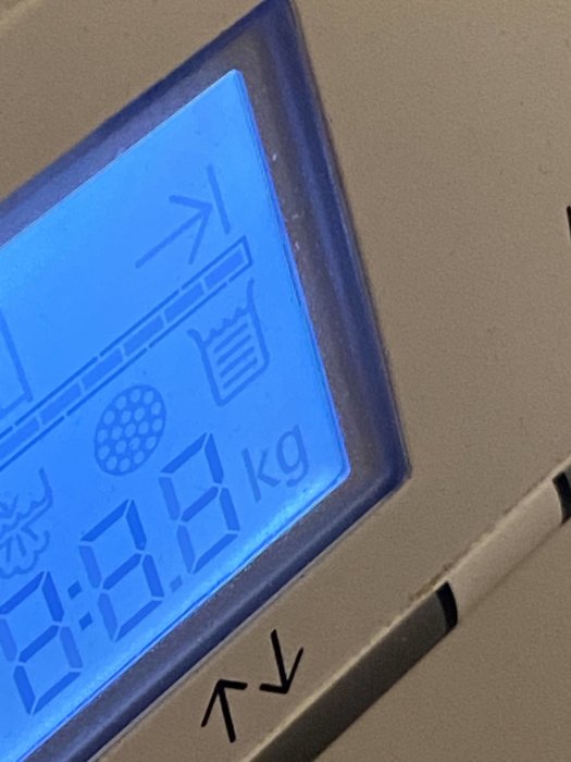 Digital display visar en okänd symbol över "kg" på en elektronisk apparat.