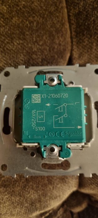 Strömbrytare med etikett från Schneider Electric, planerad att göras återfjädrande.