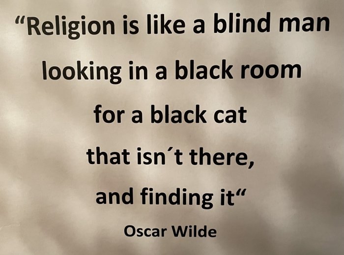 Text på en skylt med citat om religion av Oscar Wilde.