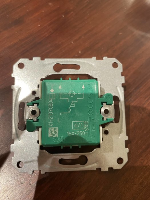 Grön Schneider Exxact strömbrytare utan kablar monterad på montageplatta.