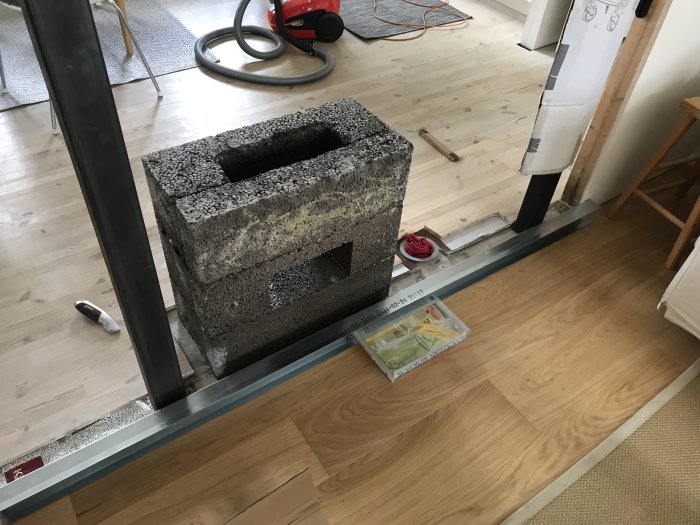 Installationsprocess för kamin med lättbetongblock på golvet och stålrörsskorsten.