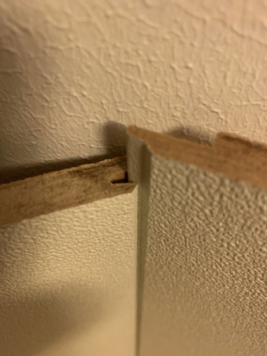 Två lösa takplattor placerade i vinkel längs en väggyta som kräver precisionsskärning.