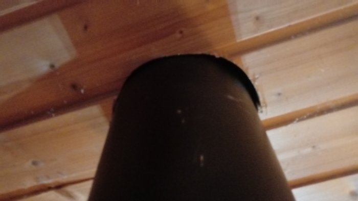 Rör som sticker ut ur ett träbeklätt tak, möjlig ventilation eller skorstensdetalj.