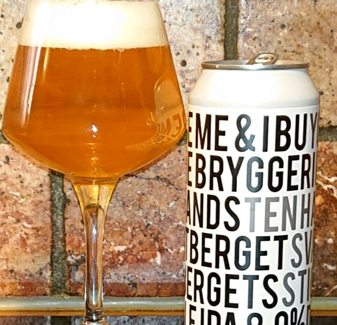 Ölglas fyllt med gyllene öl intill en burk med texten 'BRYGGERI' på en tegelbakgrund.