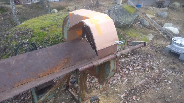 Prototyp av skydd till kapmaskin med bredare design och plats för bortstyrande plåt, placerad utomhus.