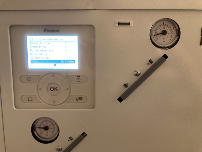Värmepumpens display med temperaturinformation och manometer för expansionskärlet.