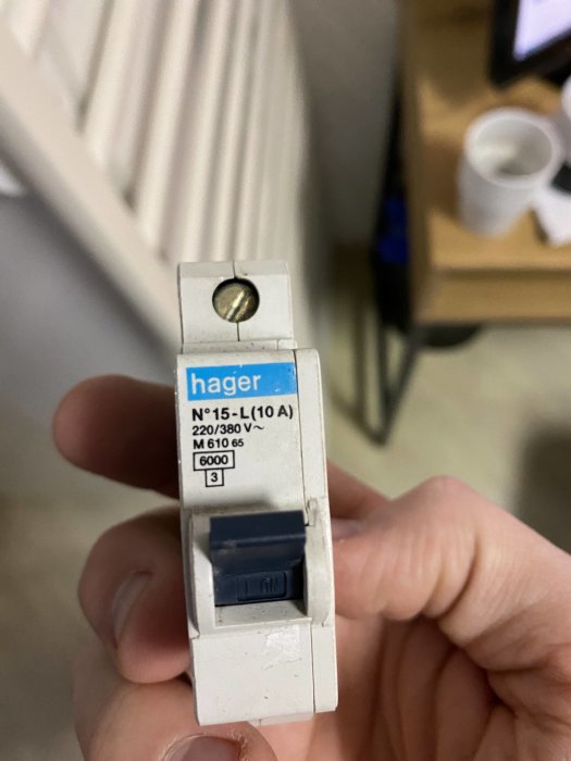 Hand håller en Hager säkring 10A för 220/380V med tekniska specifikationer.
