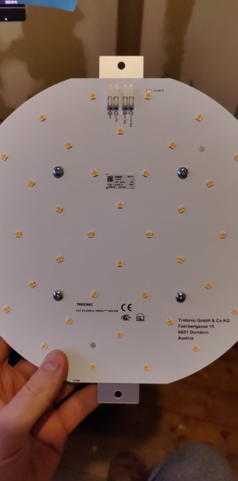 LED-modul med synliga dioder och anslutningsterminaler hålls av en hand.