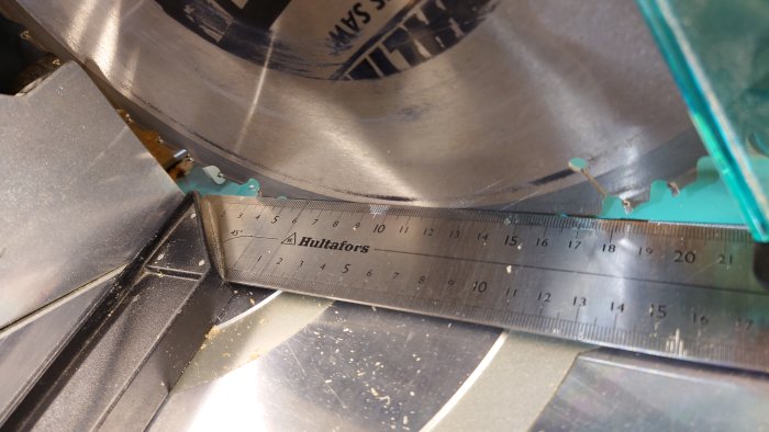 Vinkelmätare placerad mot sågklingan för att illustrera ofullständig parallelljustering mellan klingan och gejderna.