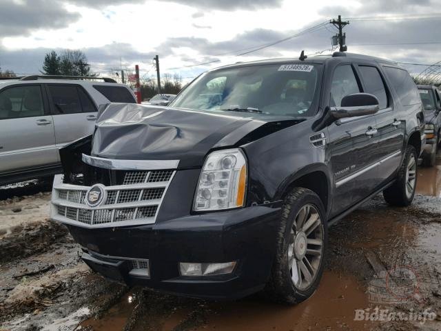 Skadad Cadillac SUV på en skrotyard, framhjulsområdet och huven bucklig och delvis täckt av plast.