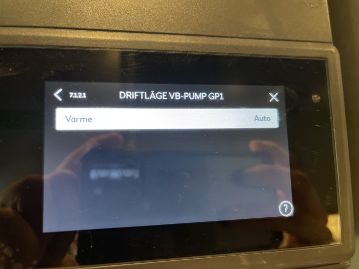 Display för VV-pump GP1 med inställningarna 'Värme' och 'Auto' synliga, användarreflektion i skärmen.