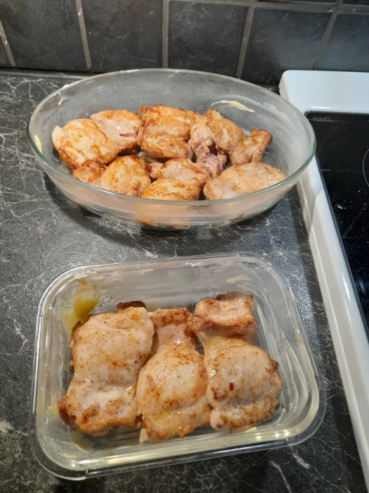 Brynt kycklinglårfilé i glasformar, förberedda för att bakas med kryddor.