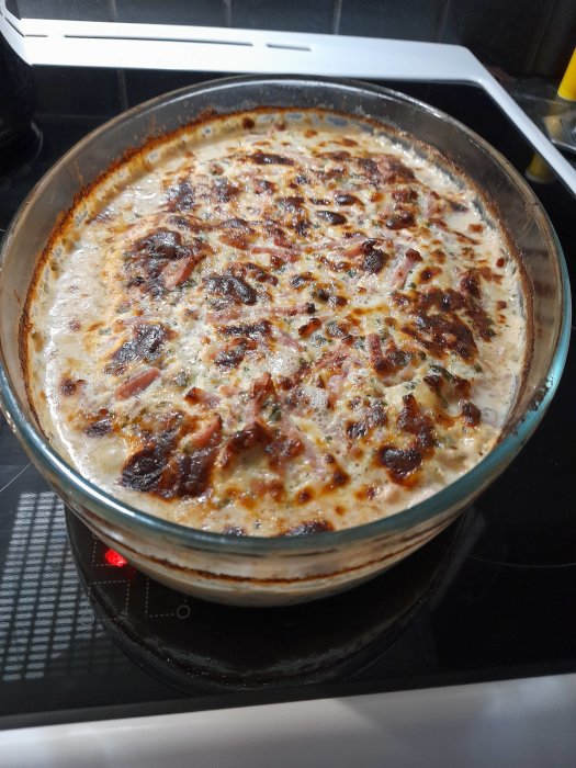 Gratinerad herrgårdskyckling i ugnssäker form, brynt till gyllene färg, serverad på spis.