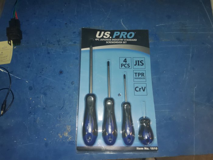 Ett set med 4 JIS-mejslar förpackade på ett blått bord, används för att lösa skruvproblem.