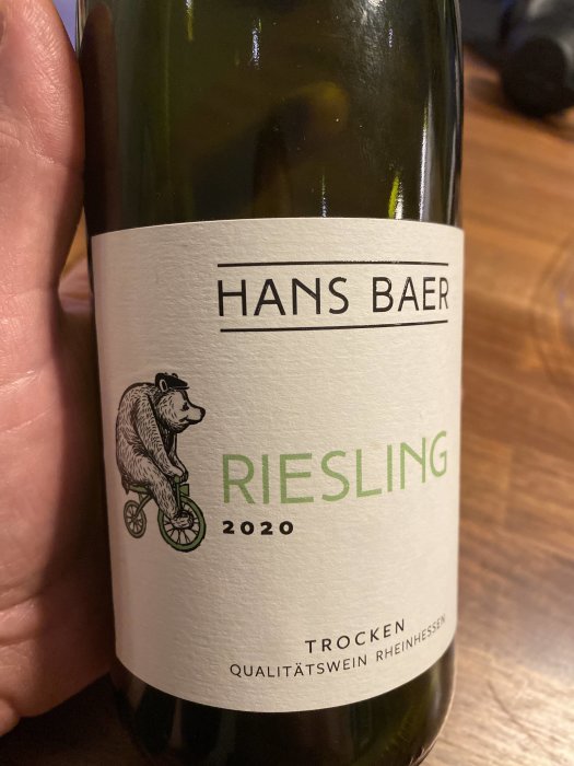 Flaska av Hans Baer Riesling 2020 vin med tecknad björn på cykel.