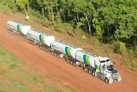 Långtradare med flera släpvagnar på en outvecklad väg, likt de i Australien för tunga transporter.