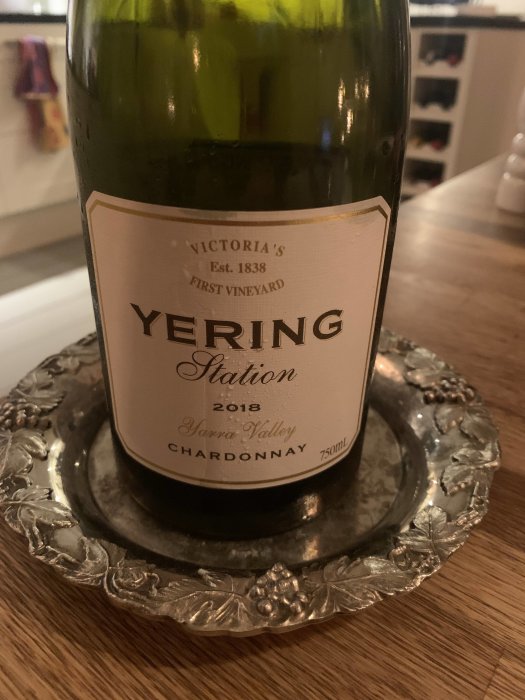 Flaska Yering Station Chardonnay 2018 på silverfat med vindruvsdekor.