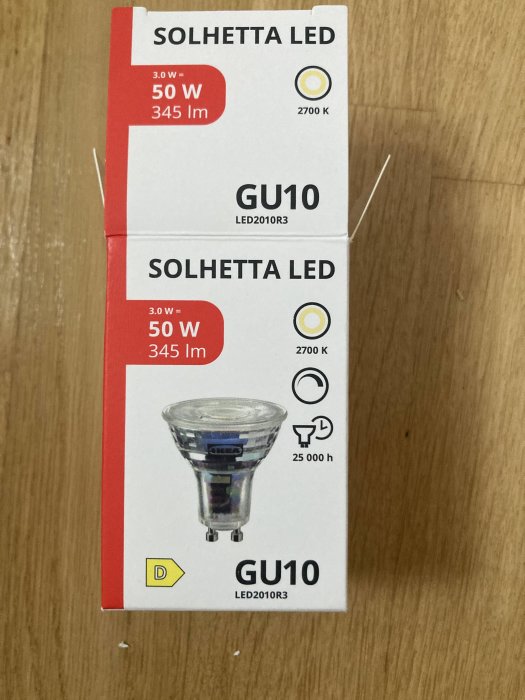 Förpackning av SOLHETTA LED, 3.0W motsvarar 50W, 345lm, GU10 från Ikea på träbakgrund.