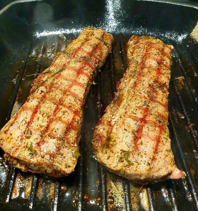 Två kryddade lammfiléer på en grillpanna.