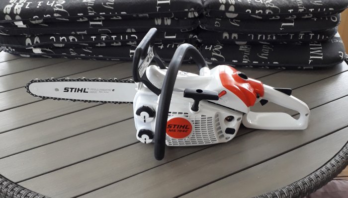 En ny Stihl motorsåg med 30 cm svärd ligger på ett träbord.
