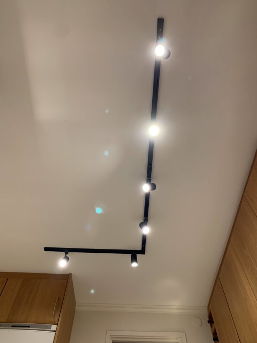 Nyinstallerad svart takarmatur med flera GU10 Philips Hue Ambiance spotlights mot vit takyta.