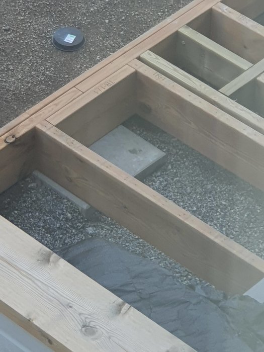 Träaltan under konstruktion med synliga balkar och betongplatta.