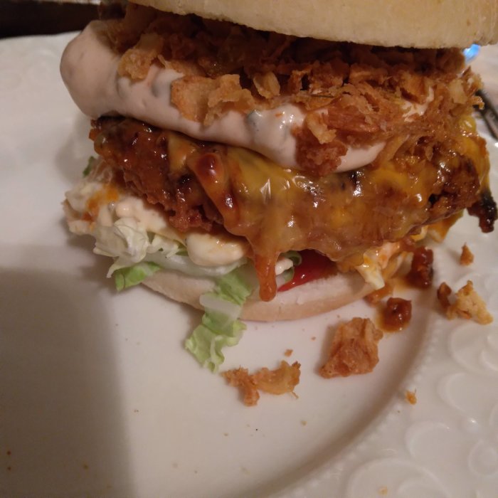 Hamburgare med cheddarost, coleslaw, picklad rödlök och bbq-fläskfärsburgare på stekt bröd.
