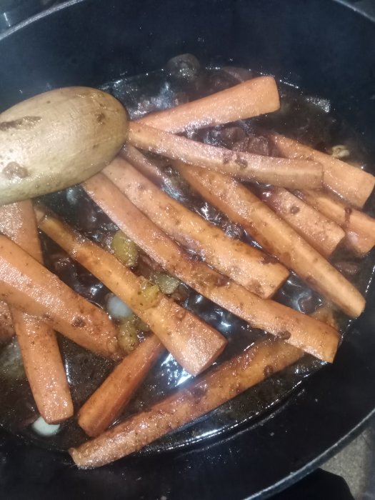 Morötter som klyfts och steks i panna tillsammans med kryddor och olja.