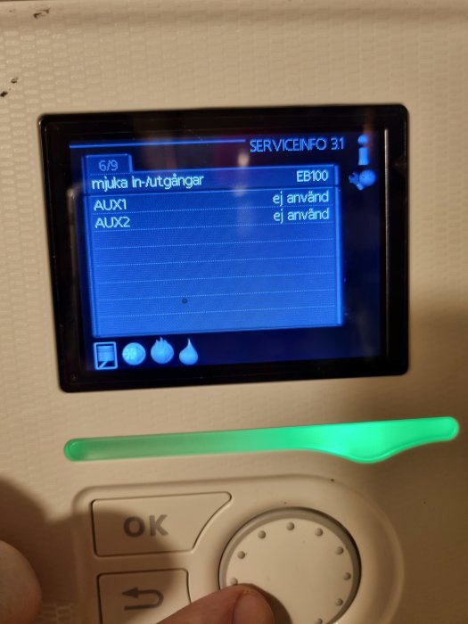 Digital termostat med display som visar servicemeny, markerad knapp och grön statusindikator.