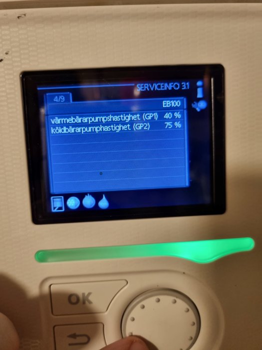 Display av en värmepumpskontroll visar hastigheter på pumparna med en grön statusindikator.