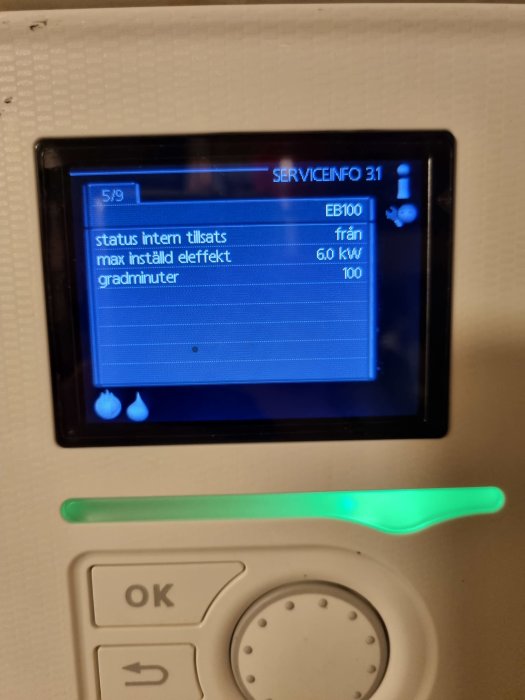 Digital panel som visar status och installerad effekt på en värmepump, med en grön lysande indikator nedanför.