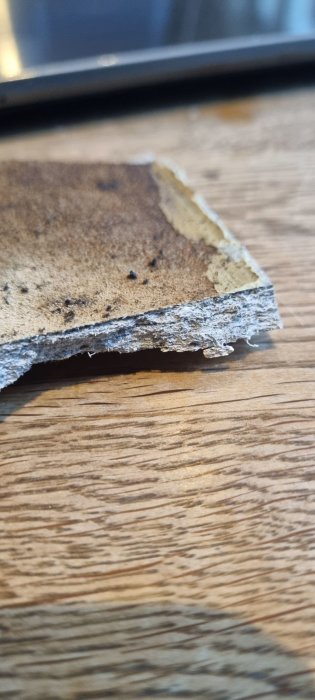 Närbild på misstänkt asbestmaterial från ett äldre ventilationssystem i ett kök.