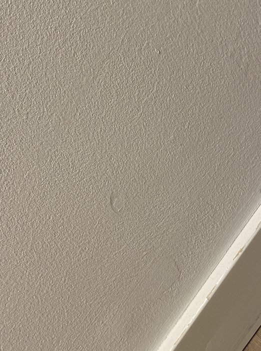 Målad och spacklad vägg med synligt problem där spacklet sjunker in efter målning.