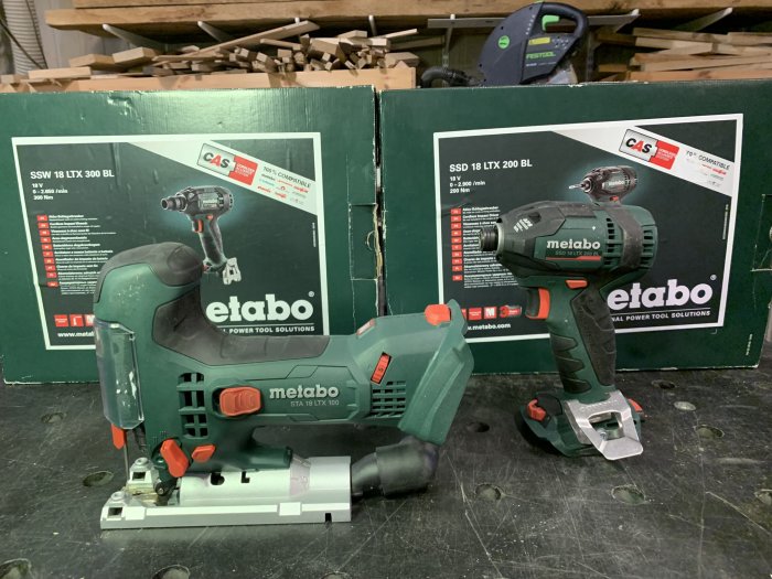 Fyra nya Metabo 18v elverktyg med kartonger på ett arbetsbord, inklusive en slagskruvdragare och sticksåg.