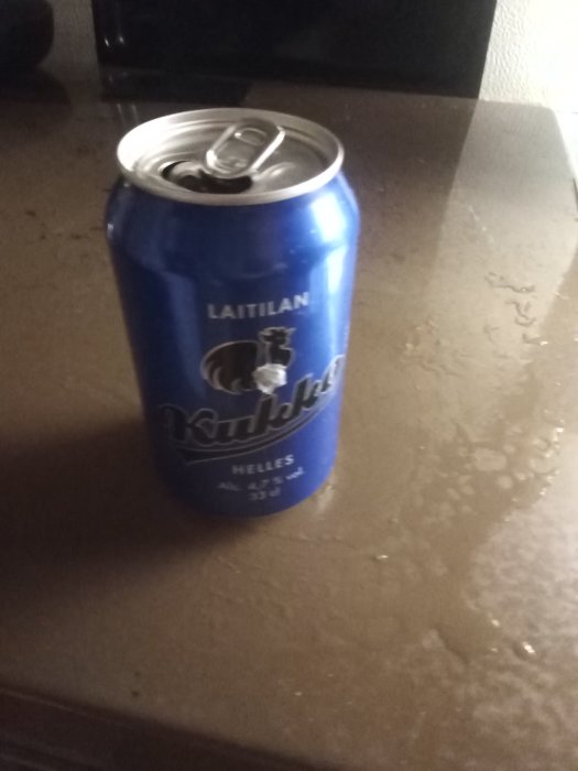 Öppnad blå ölburk på bord, "Laitilan Kukko" Helles, 4.7% alkohol, glutenfri indikation.