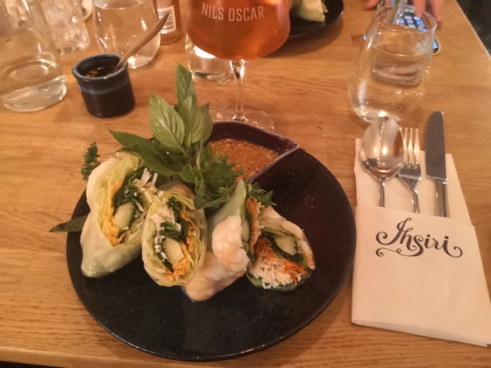En tallrik med vietnamesiska vårrullar och örtiga grönsaker, dipsås, med servett märkt 'Ihsiri'.