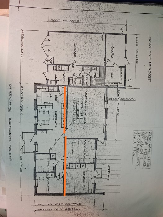 Ritning av en husplan med en markerad vägg i orange, använd för diskussion om byggprojekt.