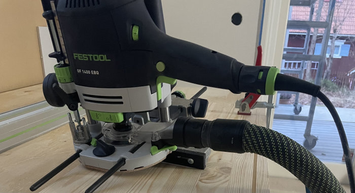 Överhandsfräs från Festool används på trämaterial med dammutsug kopplat, inomhusmiljö.