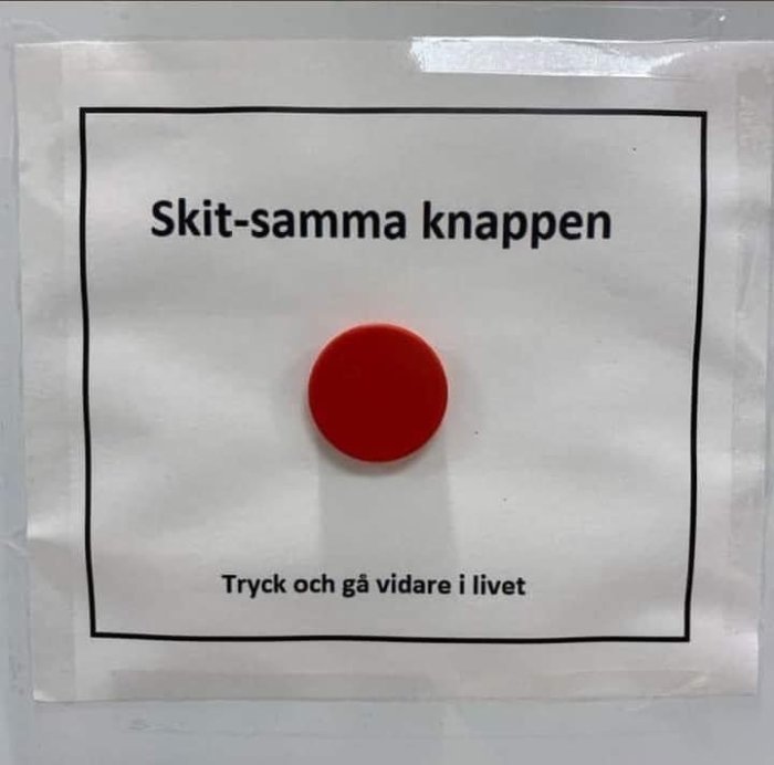 Ett papper med texten "Skit-samma knappen" och en röd knapp, undertexten lyder "Tryck och gå vidare i livet".