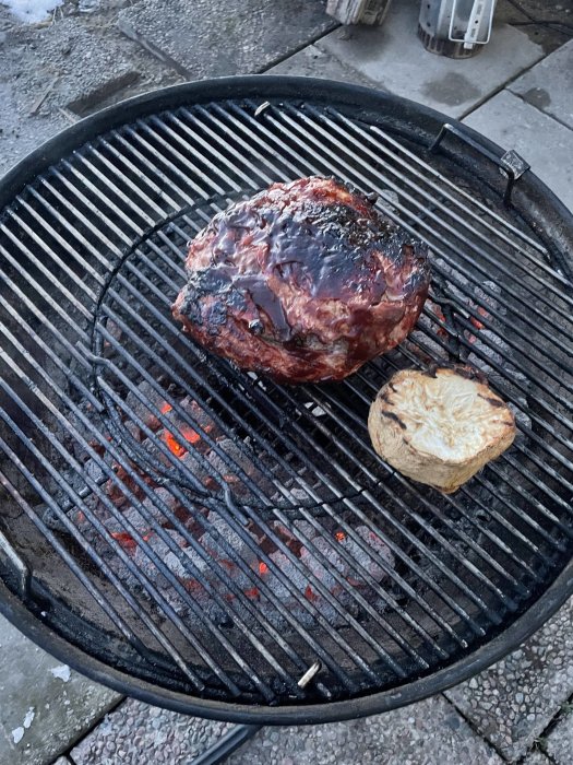 Grillad picnicbog och bakad rotselleri på en köttgrill.