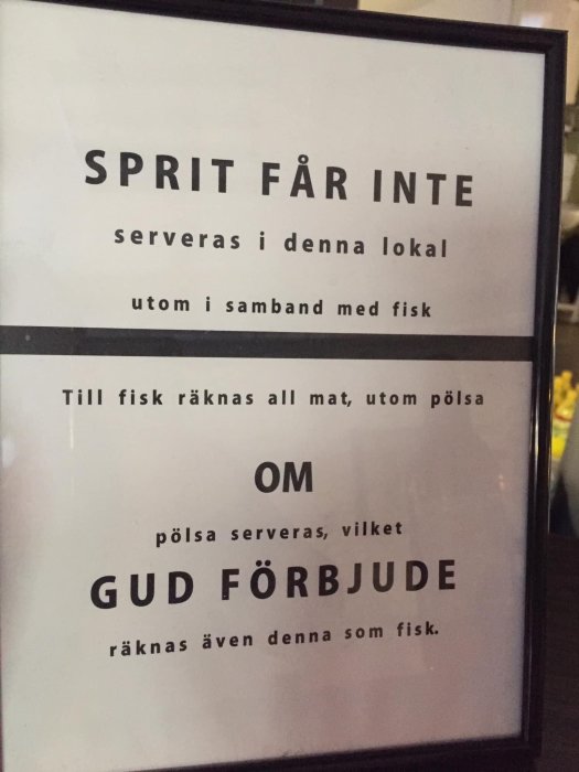 Humoristisk skylt med text som säger "SPRIT FÅR INTE serveras i denna lokal utom i samband med fisk" och definierar fisk som all mat utom pölsa.