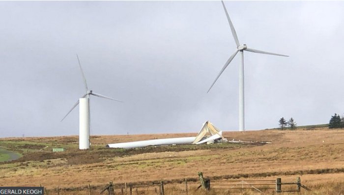 Vindkraftverk med en avbruten vinge på marken, andra turbiner intakta i bakgrunden.