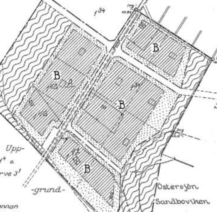 Gammal detaljplan med markerade byggplatser och omgivande parkmark nära kustlinjen.