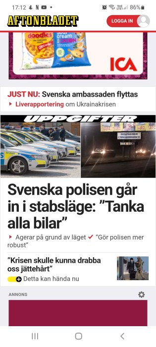 Polisbilar uppställda på rad medan poliser diskuterar vid bilarna.